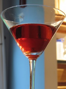 Close up of a red Negroni cocktail in a martini glass