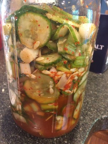 glass mason jar filled with cucumber kimchi